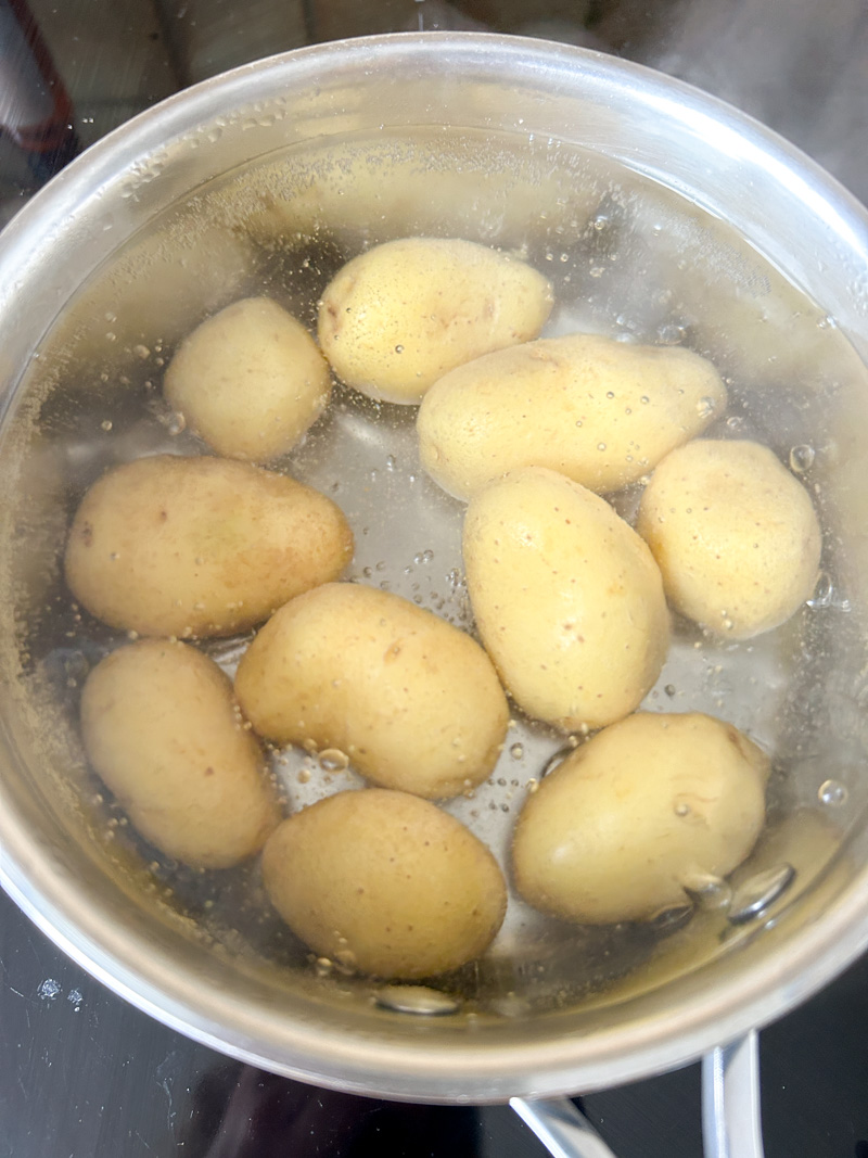Pommes de terre en train de cuire dans une casserole d'eau bouillante.