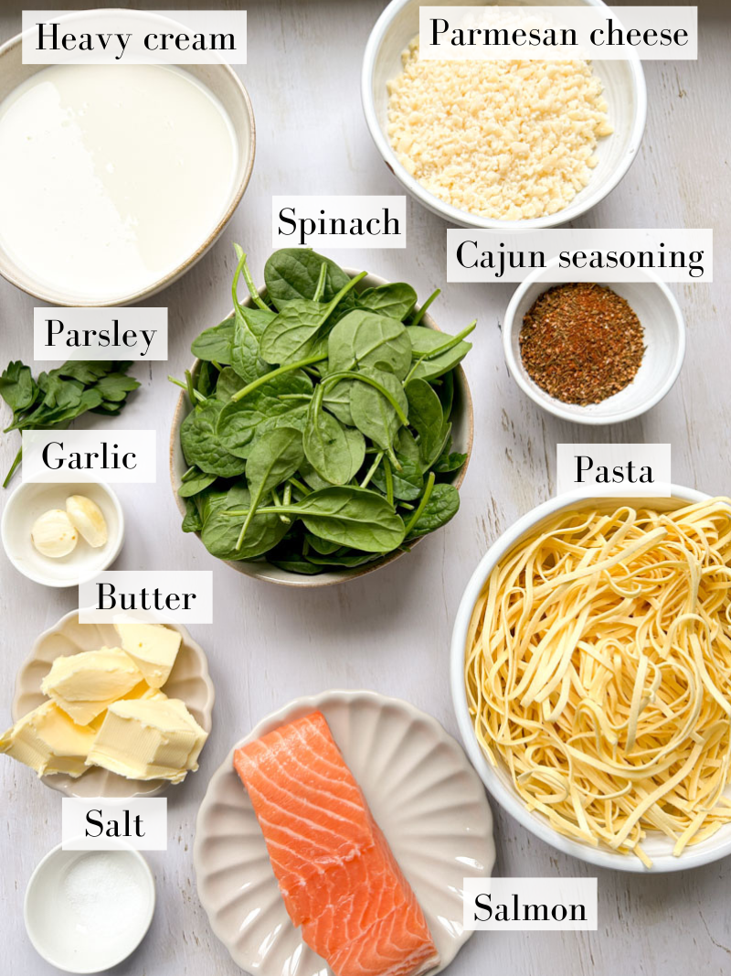 Ingredients of Cajun salmon pasta in white bowls and beige plates. 