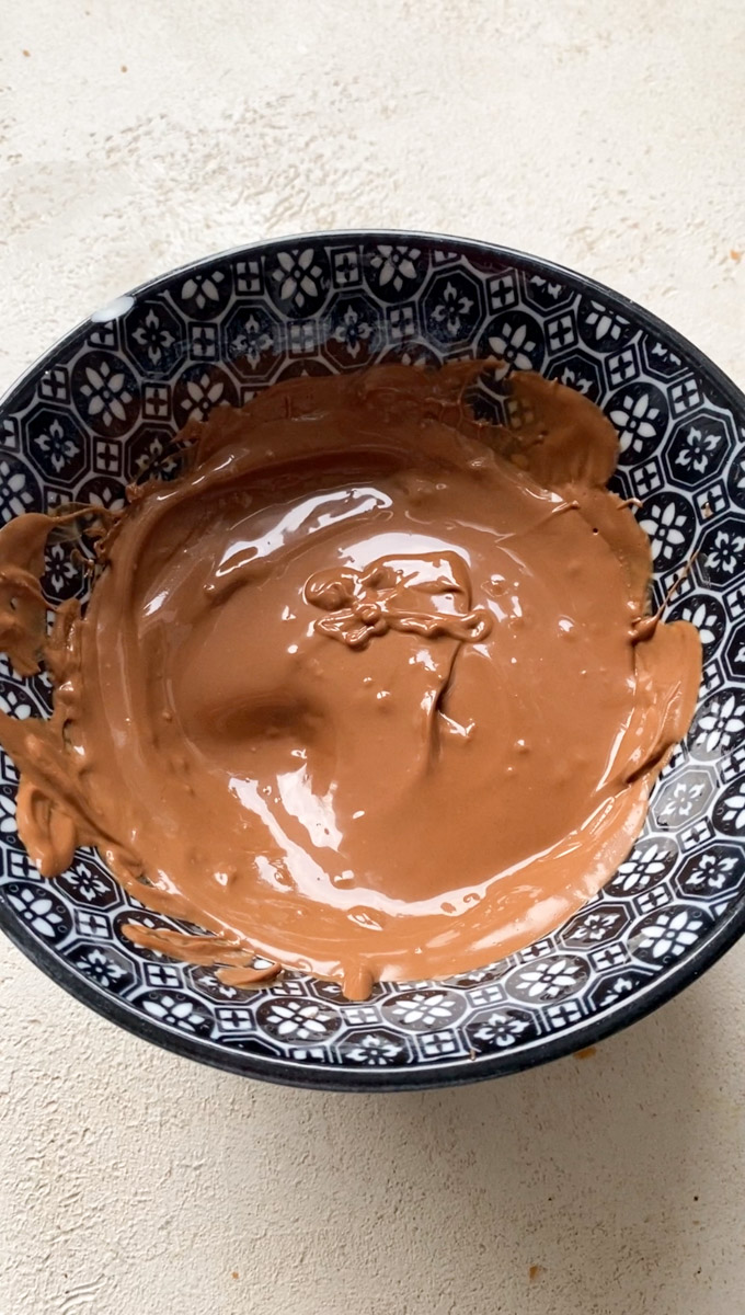 Chocolat praliné fondu dans un bol bleu marine.