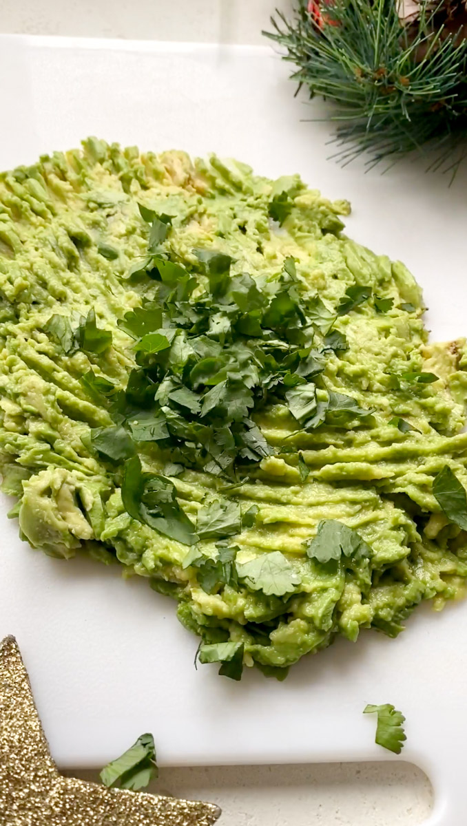 Finely chopped cilantro added to mashed avocados.