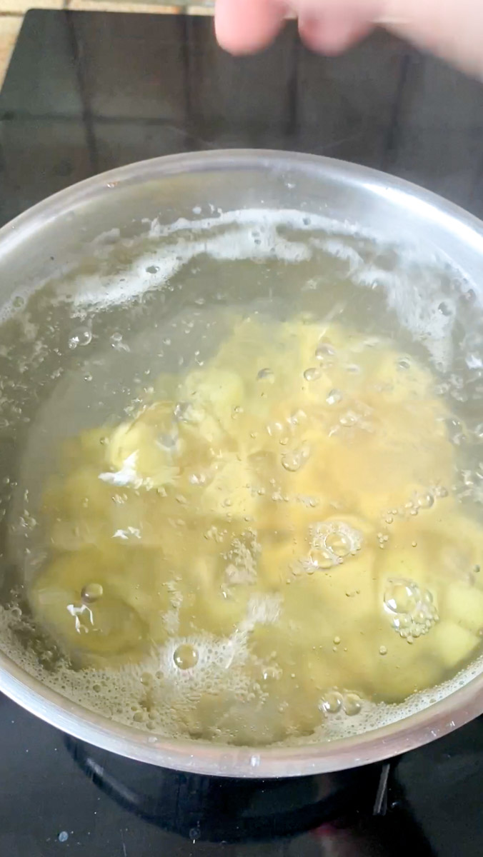 Cubes de pommes de terre qui cuisent dans une casserole d'eau bouillante.