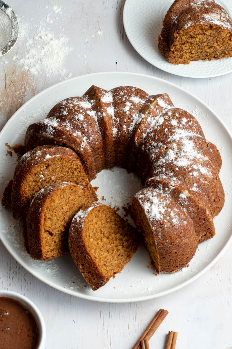 Gingerbread bundt cake cut into three slices on a white plate.