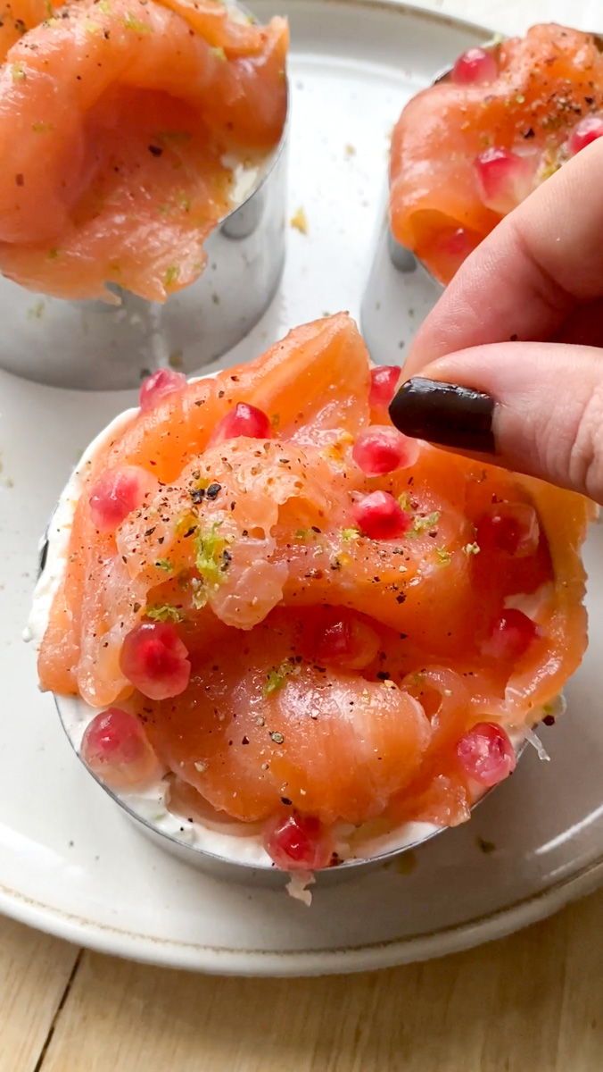 Pomegranate seeds and fresh dill are added to the smoked salmon for decoration.