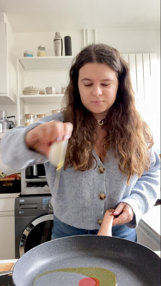 Marie pouring some truffle oil in a frying pan.