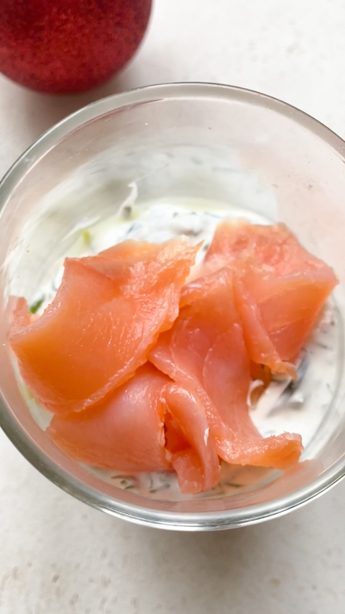 Lamelles de saumon fumé rajoutées dans le verre, sur le mélange de fromage frais.