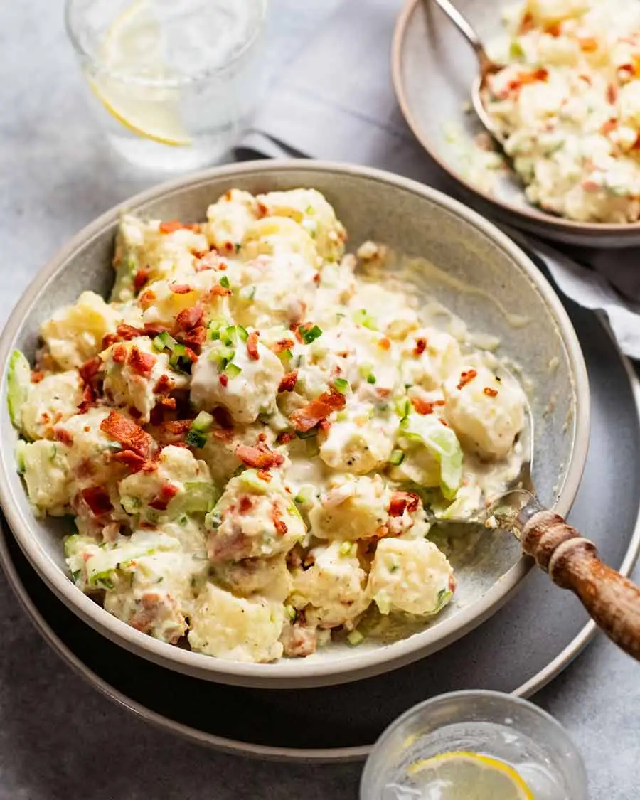 Creamy potato salad with chopped bacon and cucumber.