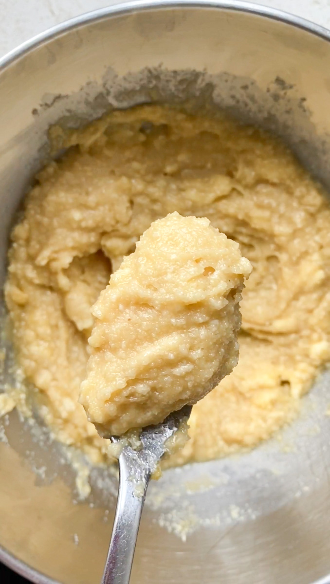 Crème d'amande prête, dont une petite partie est tenue par une cuillère à soupe.