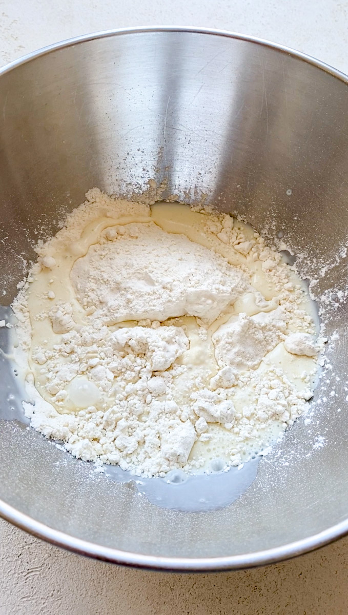 Flour and milk in a grey bowl.