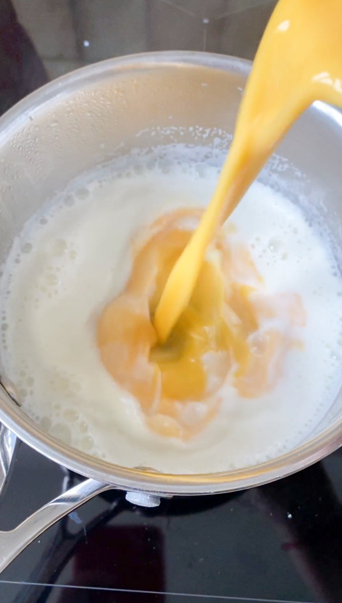 Ajout d'oeufs battus à la casserole pour réaliser la crème pâtissière.