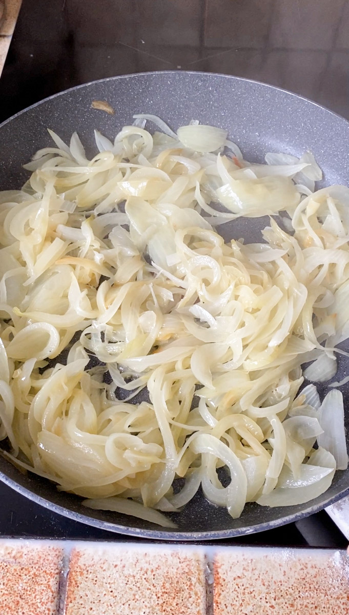 Super thin strips of onion cooking in the pan.