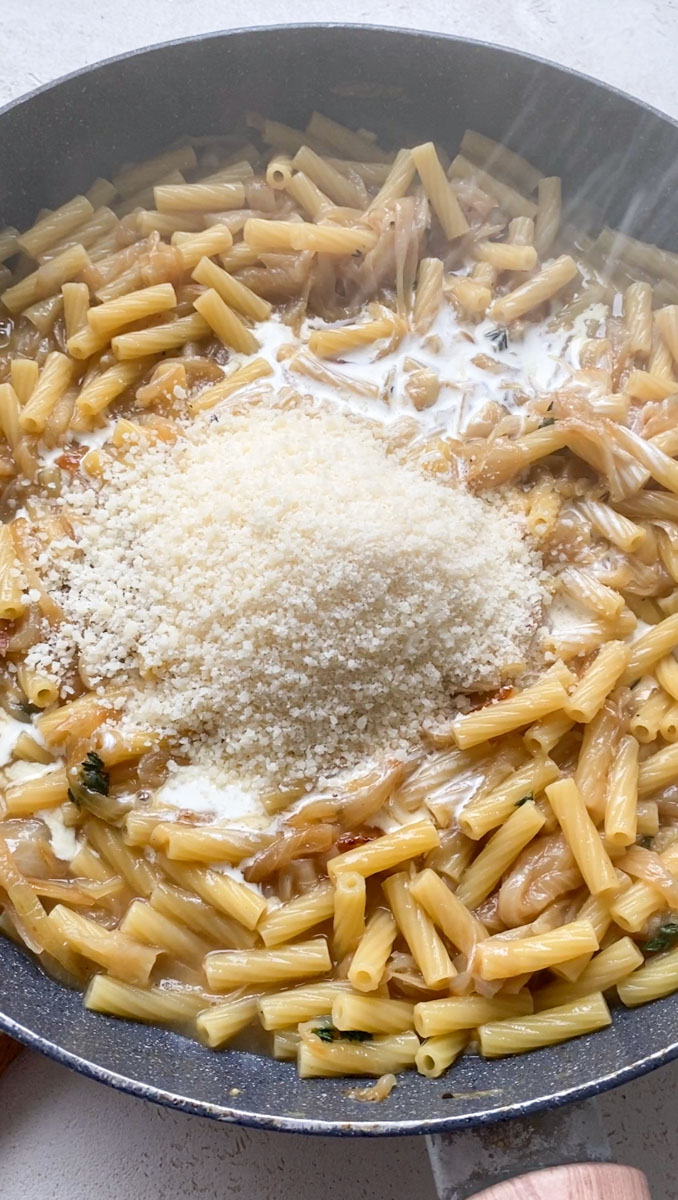 Freshly grated Parmesan added to the pan of cooked pasta.