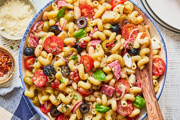 Salade de pâtes avec des tomates cerises, des olives et des coeurs d'artichaut.