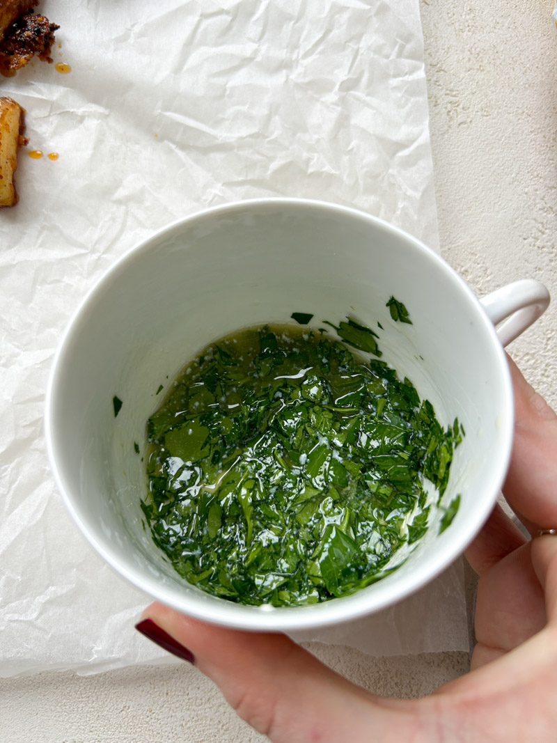 Melted butter and parsley mixture in a white mug.
