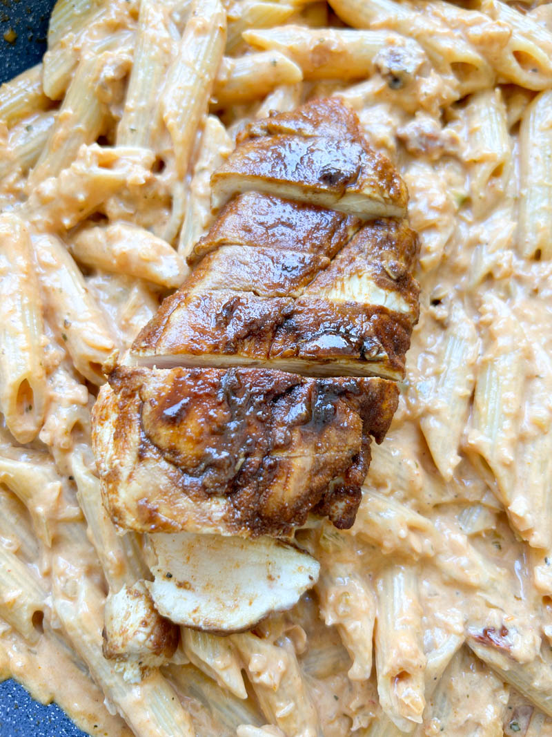 Sliced chicken breast on top of the pastas.