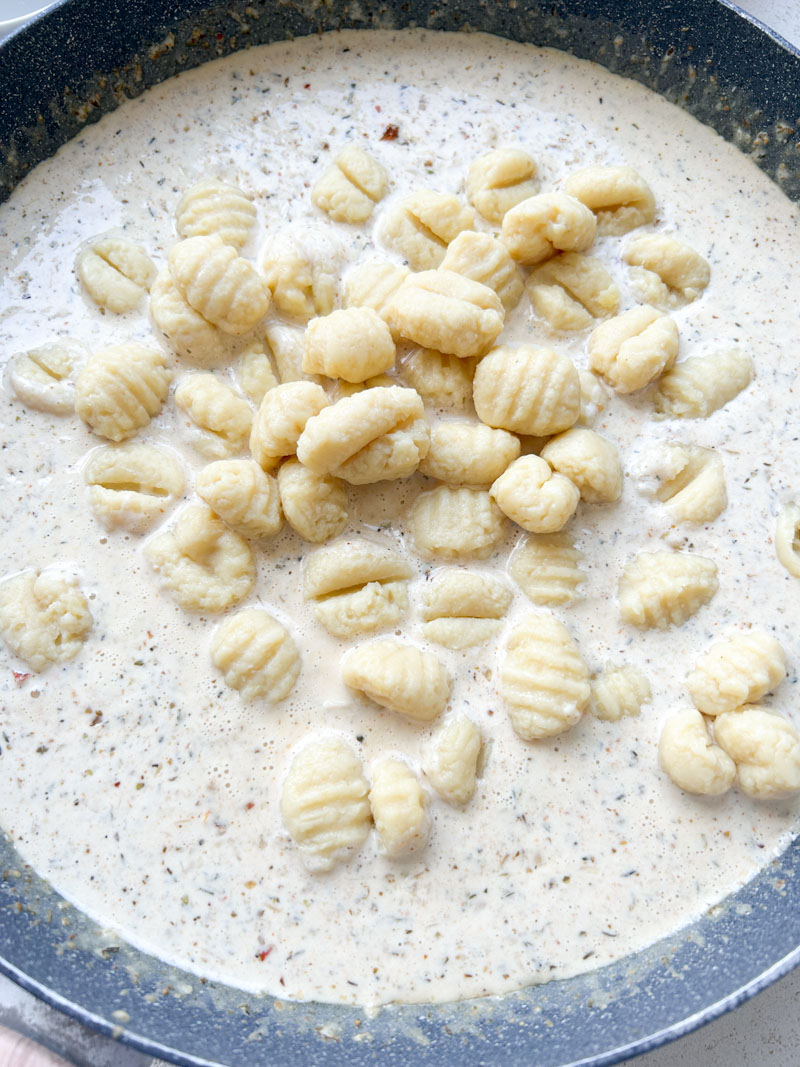Gnocchi added to pan of sauce.