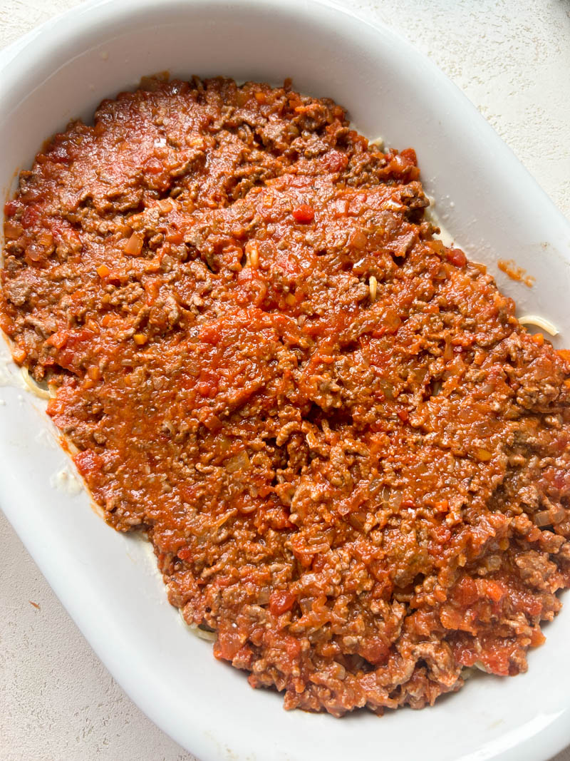 Sauce à la tomate et viande ajoutée sur les spaghettis Alfredo.