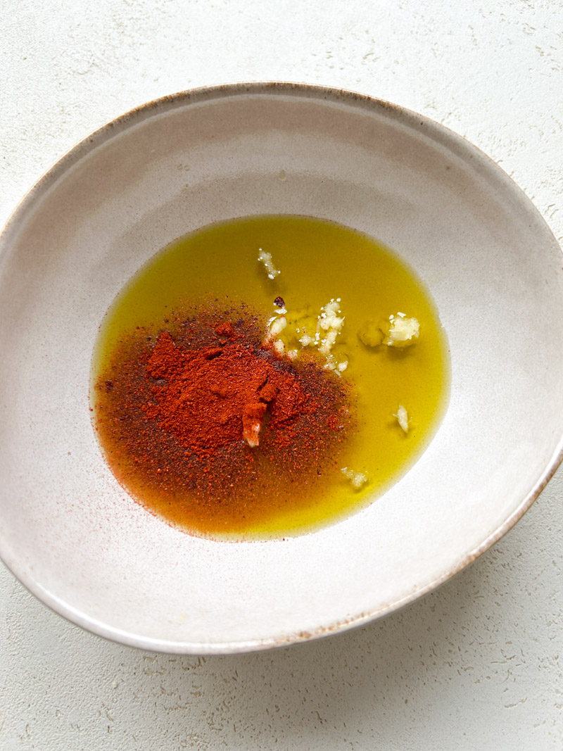 Paprika added to the bowl of olive oil.