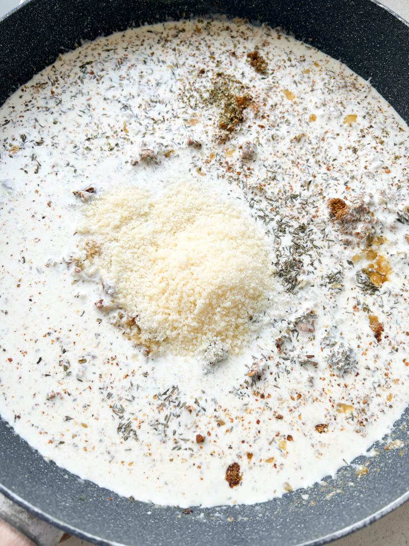 Freshly grated Parmesan cheese added to the frying pan.