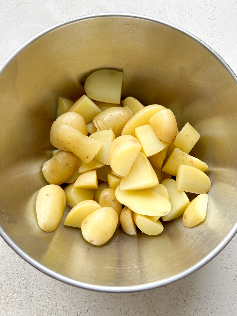 Boiled half potatoes in a grey bowl.