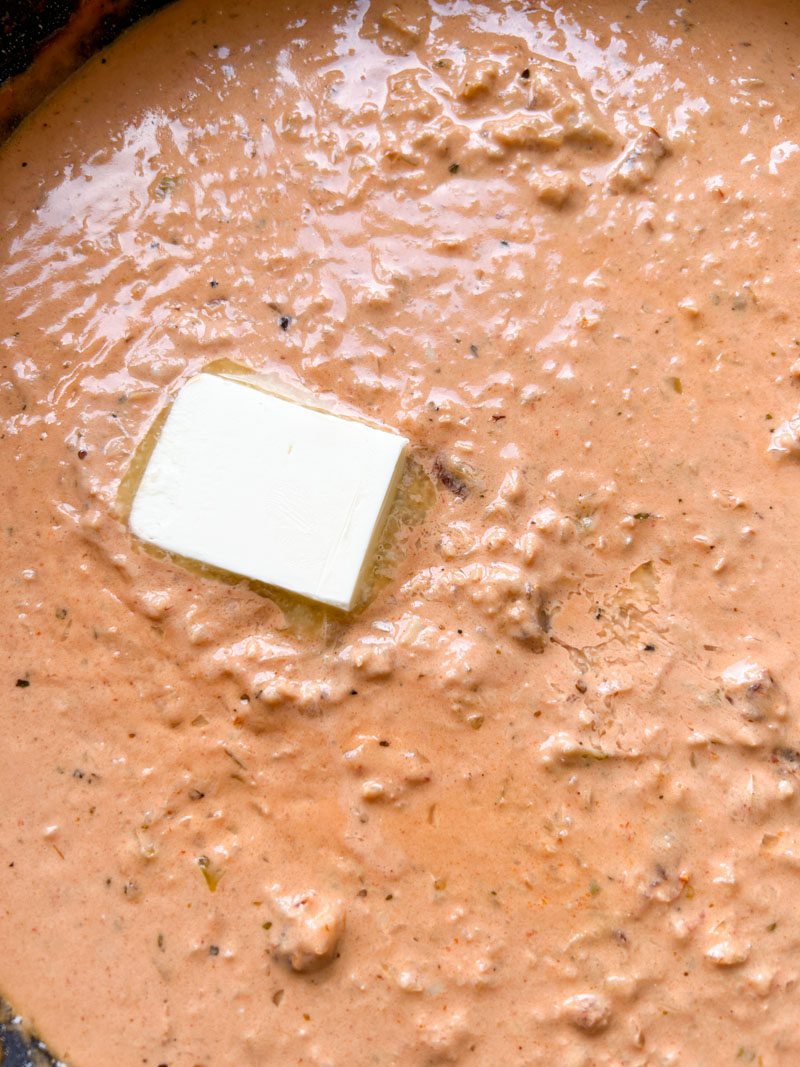 Un petit carré de beurre ajouté à la poêle de sauce rouge.