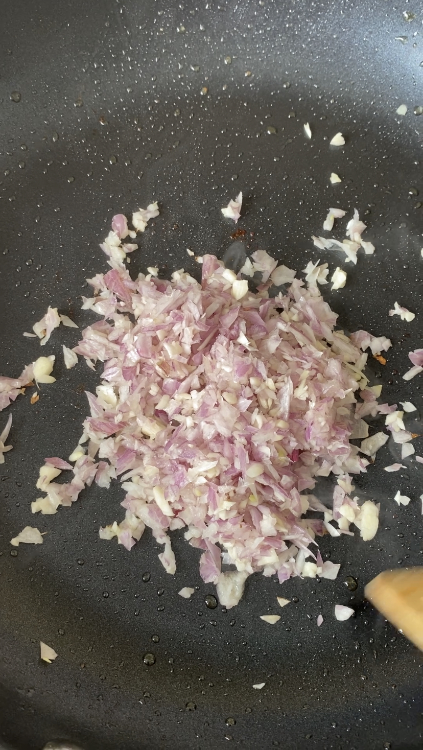 Minced shallot and garlic cooking in a skillet.