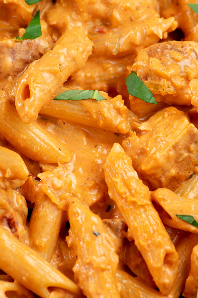 Creamy pasta with pieces of chicken and freshly chopped basil.
