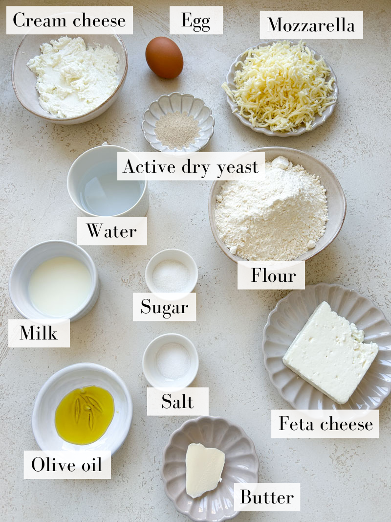 Khachapuri's ingredients in beige and white bowls and plates.