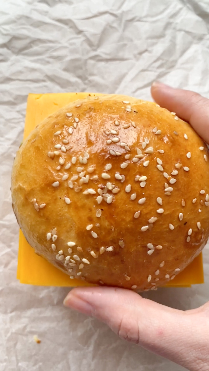 Le pain à burger est placé sur les tranches de cheddar.