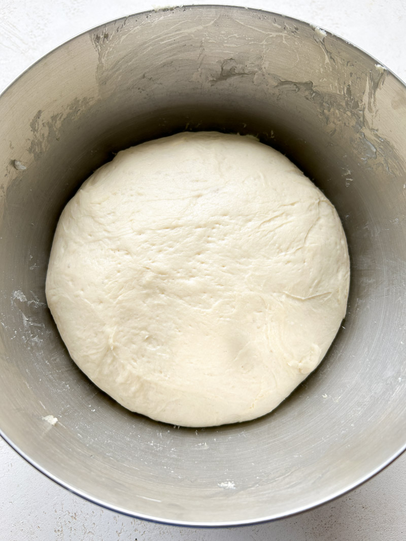 The dough ball into the stand mixer's bowl, after its first rise.