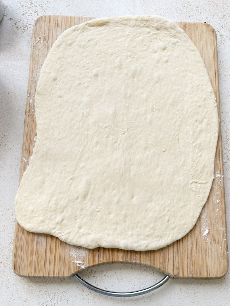 The Khachapuri's dough is rolled out into a rectangle.