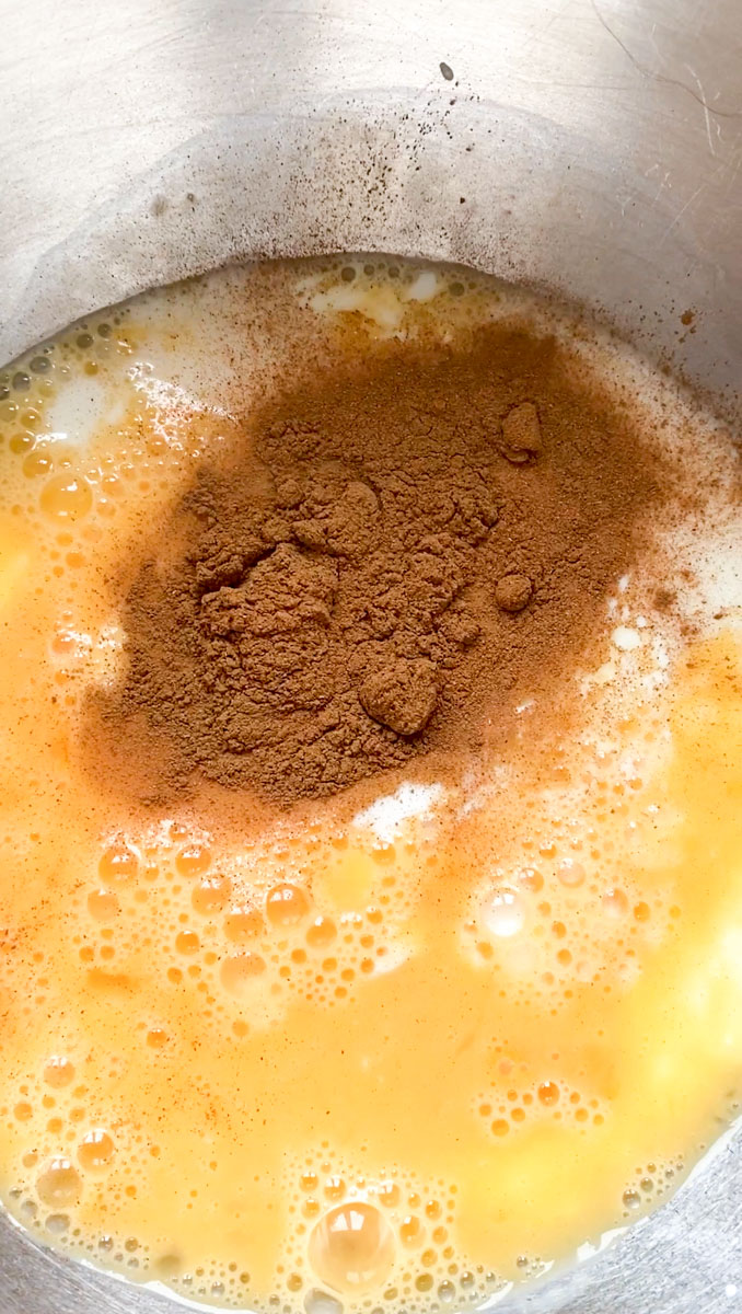 Ground cinnamon added to the bowl of eggs and milk.