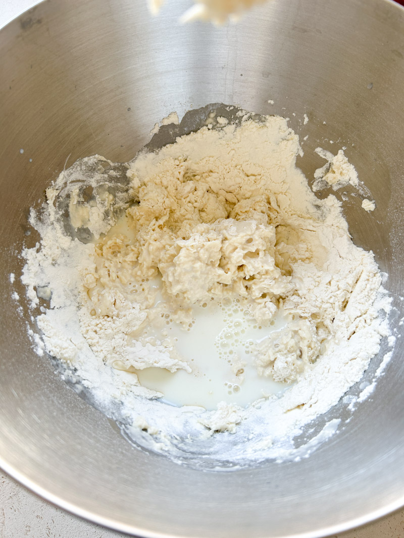 Milk added to the flour and water mixture, in the stand mixer's bowl.