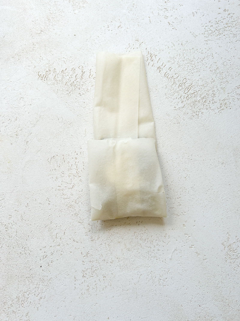 The bottom of the fillo pastry sheet is folded over the garnish.