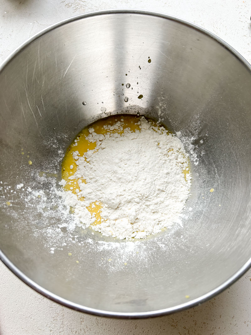 Flour added to bowl of egg yolk and sparkling water.