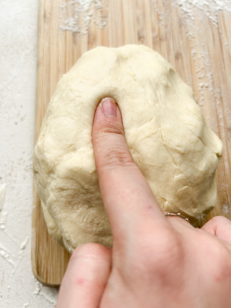 Un doigt appuie sur la pâte pour voir si elle est prête à lever.