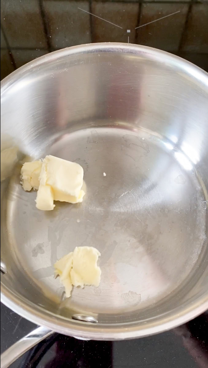 Morceaux de beurre en train de fondre dans une casserole.