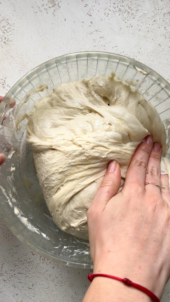 A hand that folds the dough over itself.