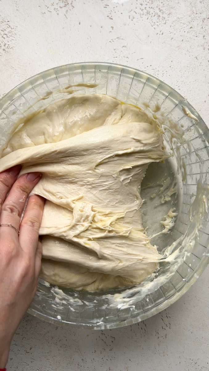 A hand that folds the dough over itself.