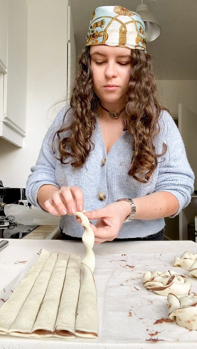 Marie twisting a strip of puff pastry and Nutella.