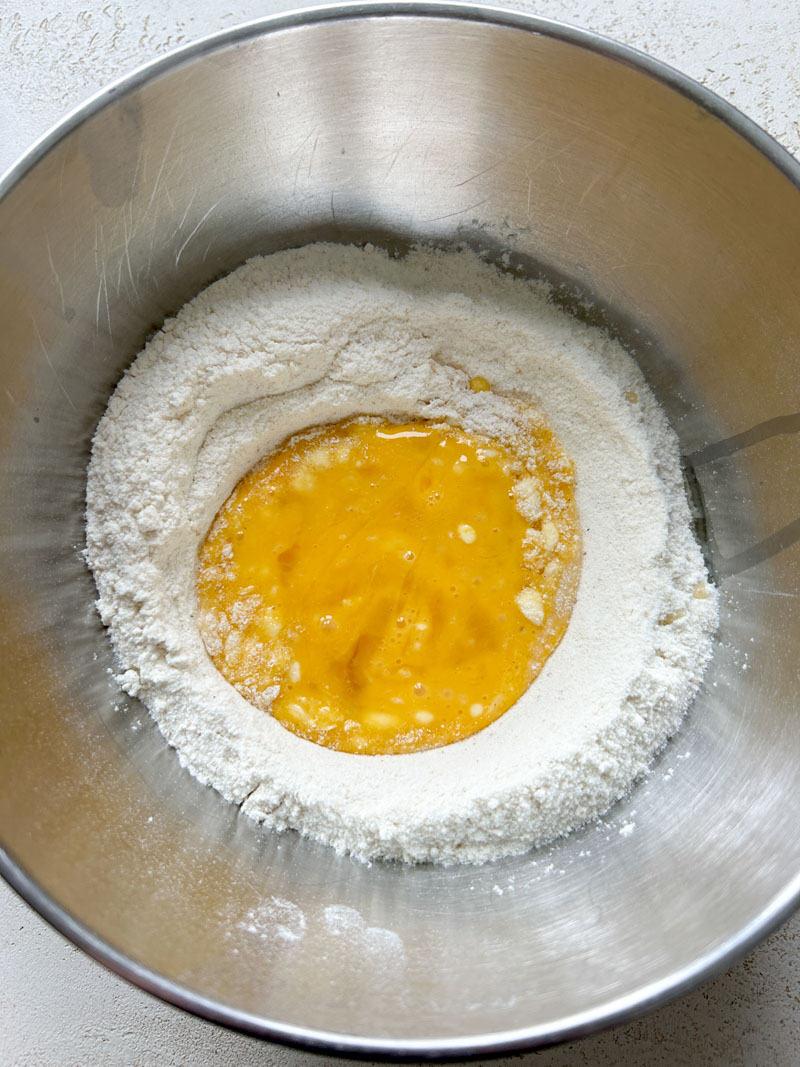 The eggs have been beaten and are still in the well, in the middle of the flour.