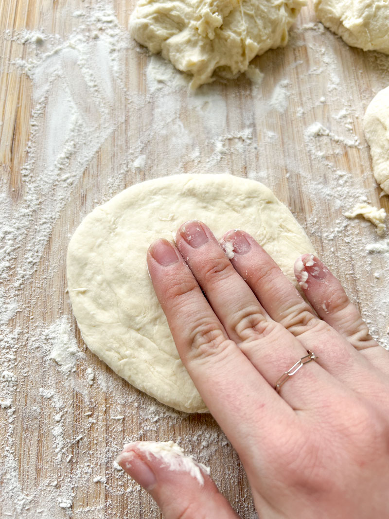 Hand lowering a dough piece.