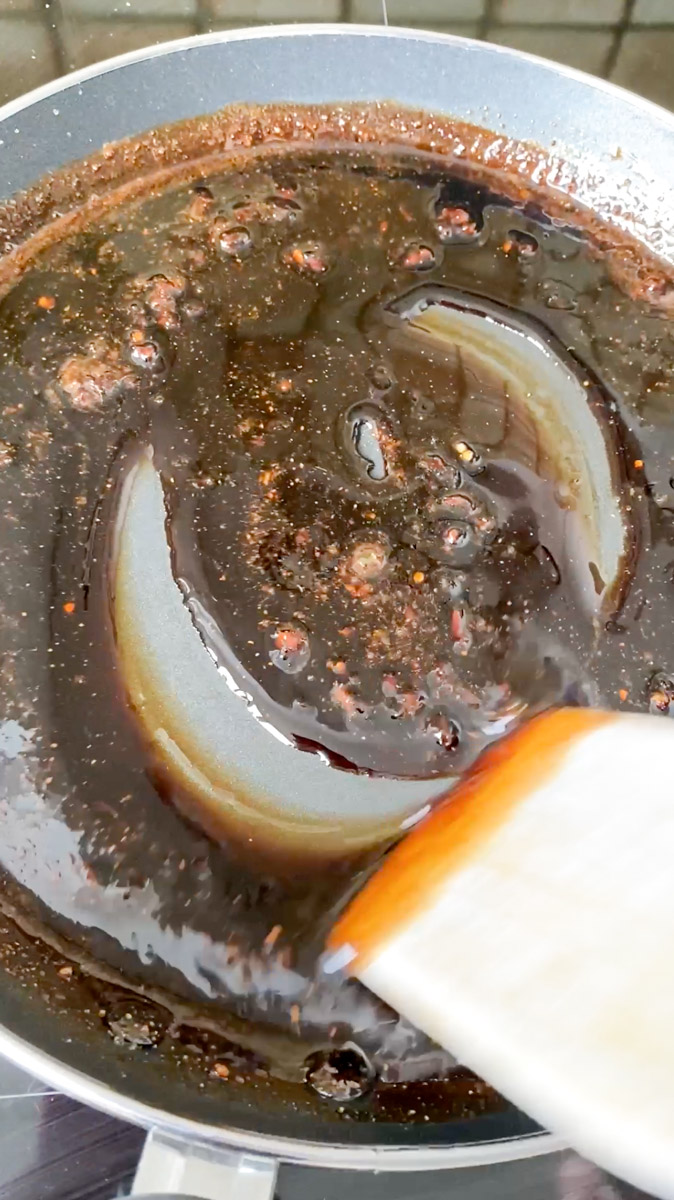 The homemade Teriyaki sauce is cooking and thickening in a frying pan.