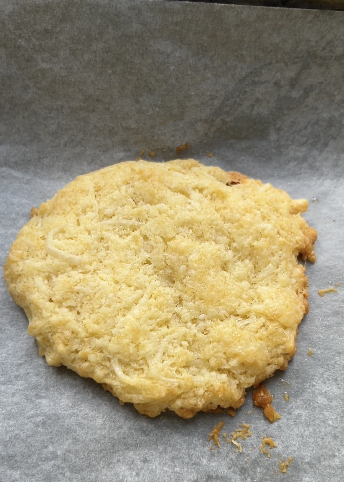 Savory cookie after baking, on a sheet of parchment paper.