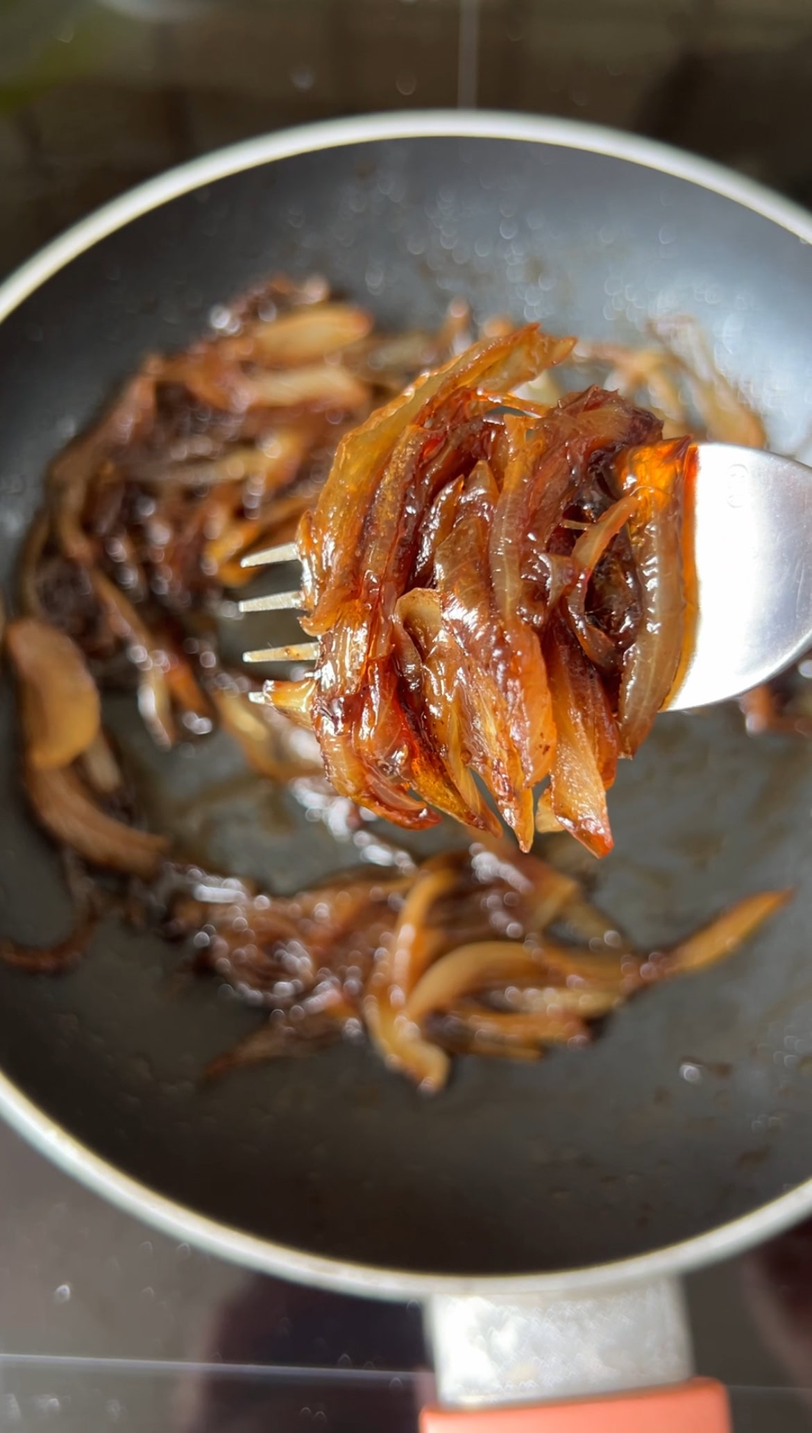 A few slices of onion confit held together with a fork.