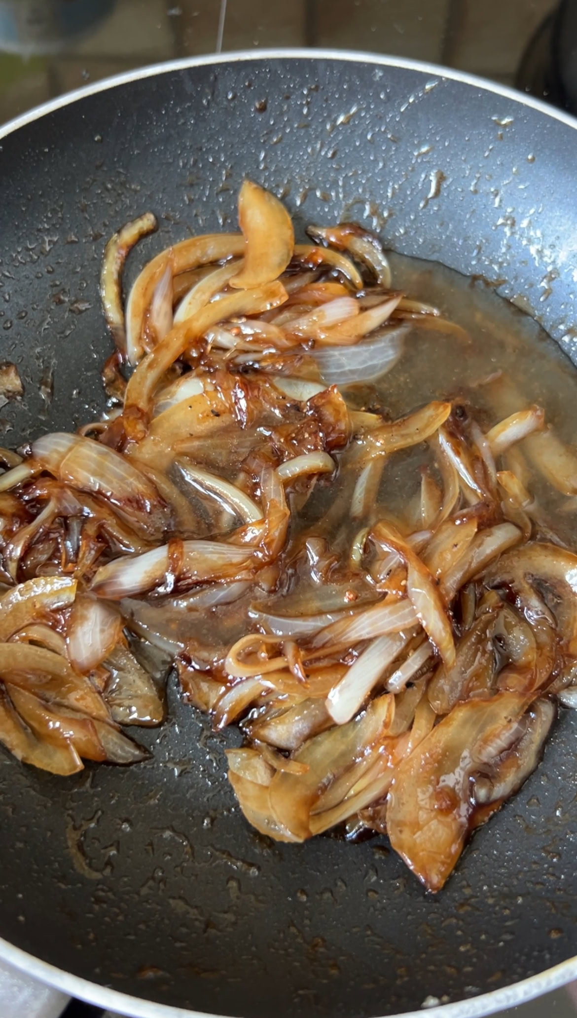 Water added to pan-fried onion slices.