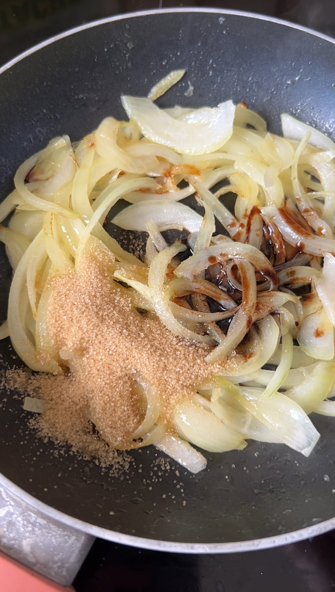 Vinegar added to onion slices as they cook.