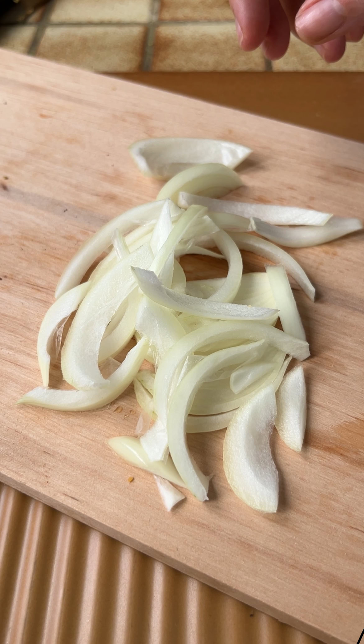 Onion slices on a wooden board.