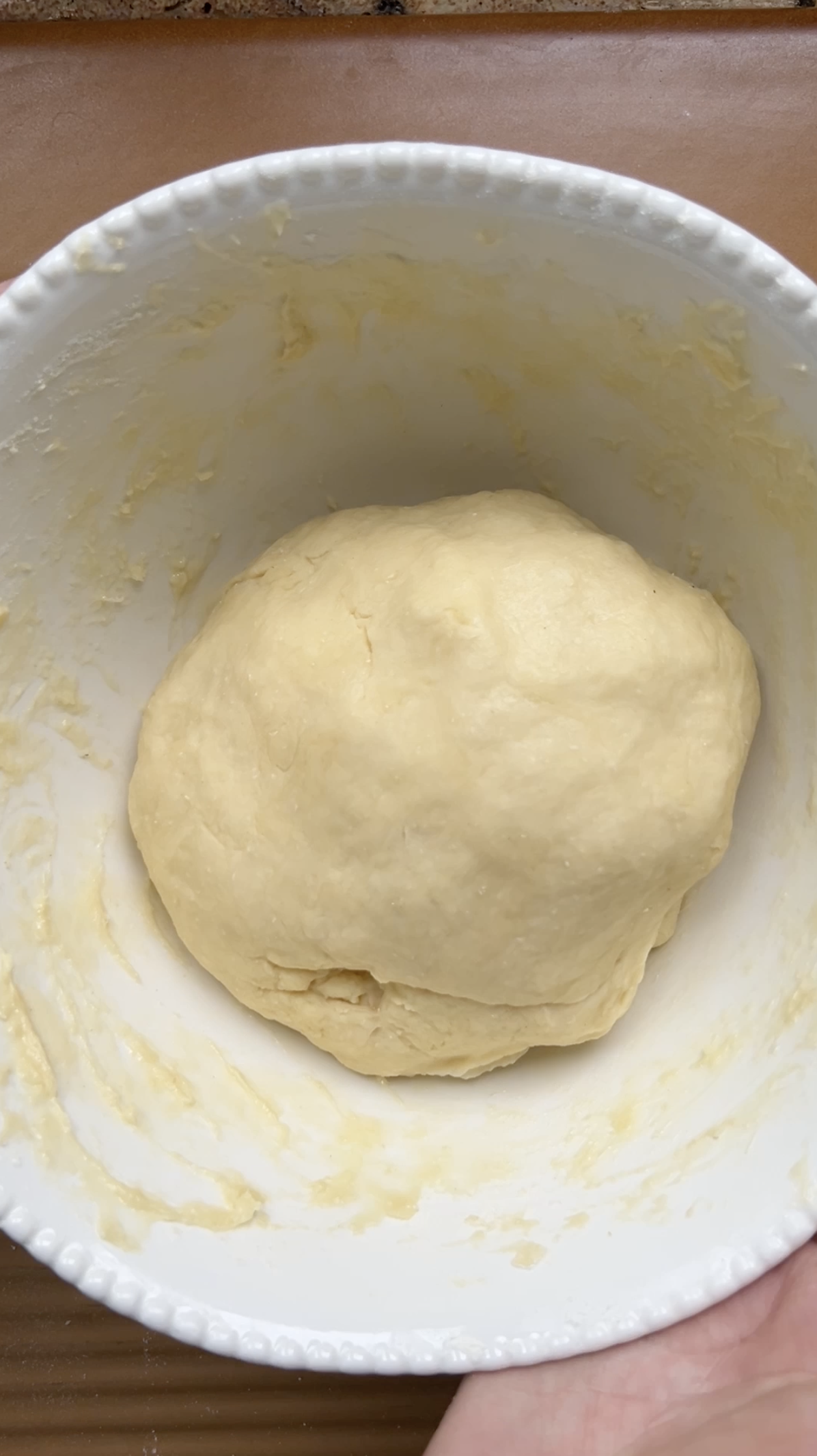 La boule de pâte placée dans un bol blanc, avant la première levée.