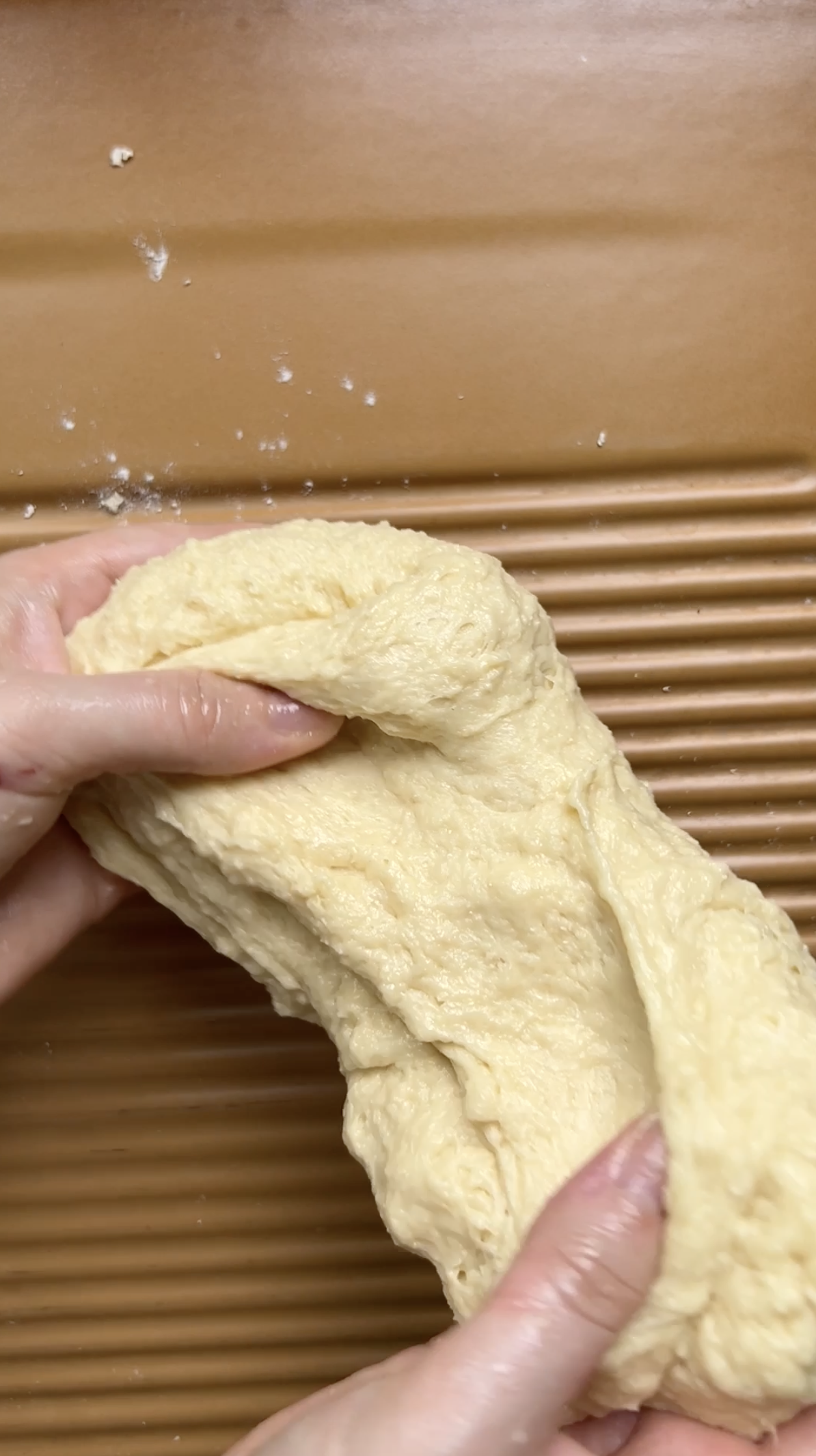 Deux mains étirent la pâte.