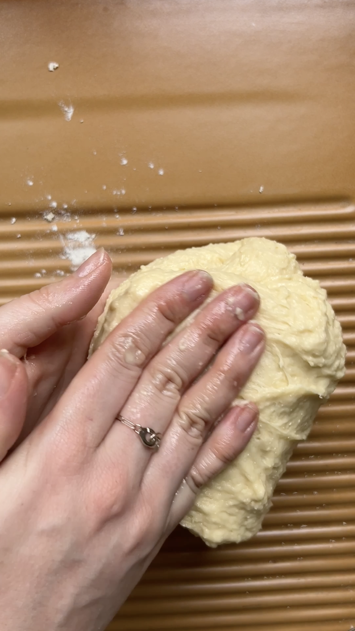 Deux mains rabattent la pâte.